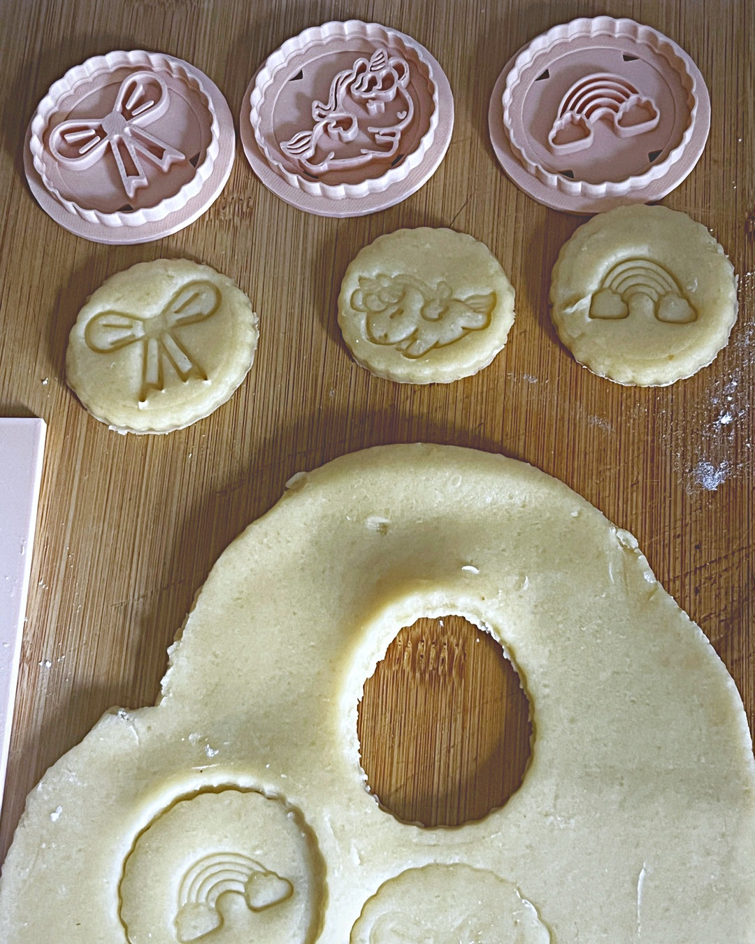 Découpe des biscuits licorne, nœud et arc-en-ciel dans la pâte sablée